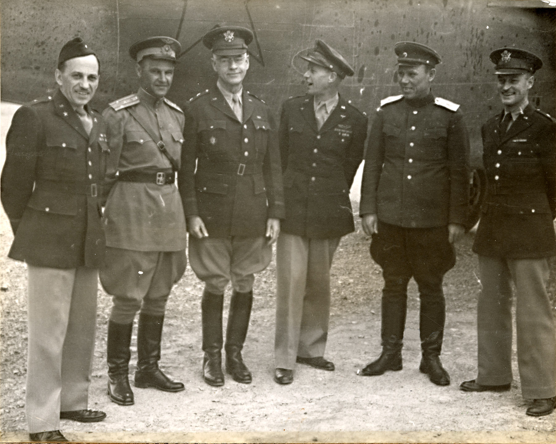 Six military officers stand before an airplane Six military officers stand before an airplane